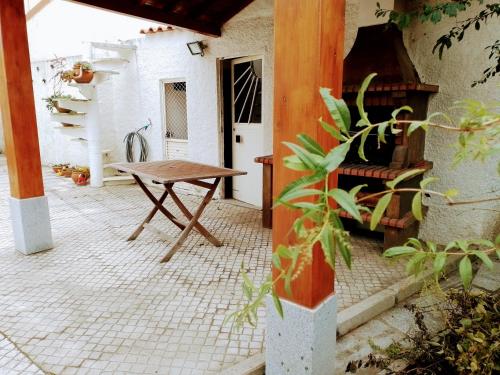 a patio with a wooden table and a bench at Casa dos Quatro Irmãos in Gouveia