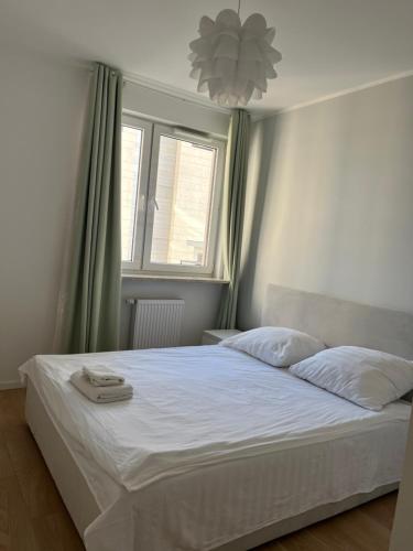 a bedroom with a bed with white sheets and a window at airport cybernetyki2 inn in Warsaw