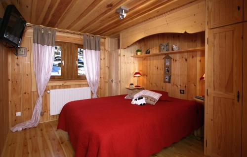 - une chambre avec un lit rouge et un chien dans l'établissement Odalys Chalet Leslie Alpen 2, à Les Deux Alpes