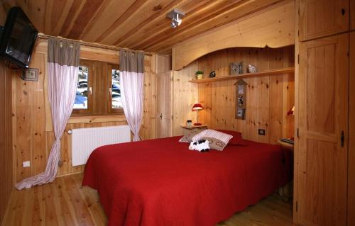 a bedroom with a red bed with a dog on it at Odalys Chalet Leslie Alpen 2 in Les Deux Alpes