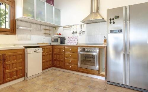 a kitchen with stainless steel appliances and wooden cabinets at Vistas a Moraira in Teulada