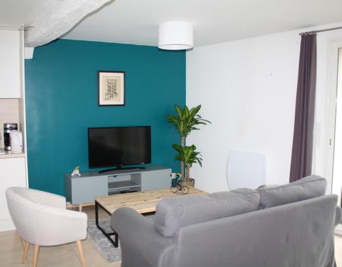 ein Wohnzimmer mit einer Wand mit blauen Akzenten in der Unterkunft L'inattendue - Maison centre ville - Dourdan in Dourdan