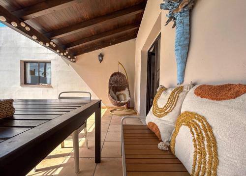 een slaapkamer met een bed en een houten bank bij Boho Palm in Corralejo