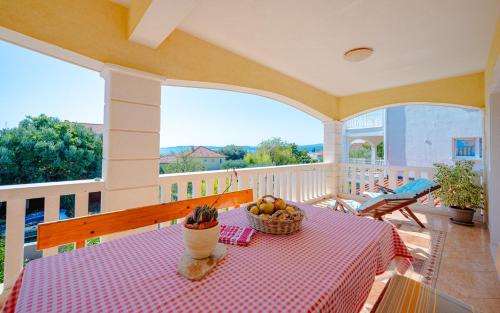 a table with a bowl of fruit on a balcony at Apartments Mladenka in Orebić