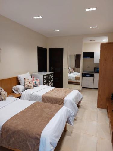 a hotel room with three beds and a kitchen at Marron studios 3A in Cairo
