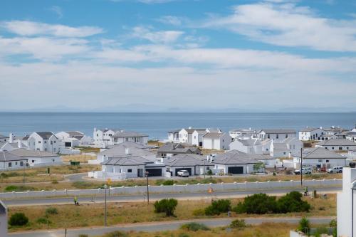 a row of white houses in front of the ocean at Forever Blue in St Helena Bay