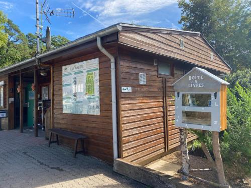 un petit bâtiment avec un panneau devant lui dans l'établissement Camping la Faloise, à Angicourt