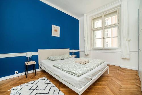 1 dormitorio azul con 1 cama con pared azul en Cozy apartment in hipster area, en Praga