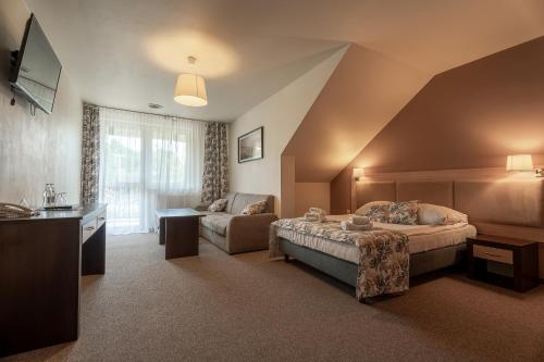 a hotel room with a bed and a couch at Hotel Cztery Pory Roku in Głogów Małopolski