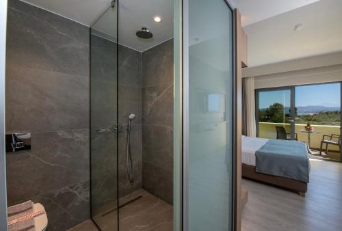 a bathroom with a shower and a bedroom with a bed at MARE GARDEN in Georgioupolis