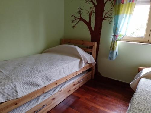 a bedroom with a bed with a tree mural on the wall at Casa dos Quatro Irmãos in Gouveia
