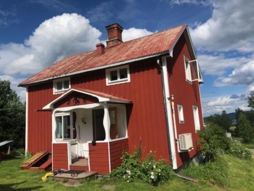 un granero rojo con techo rojo en Huset i skogen med utsikten en Vallsta