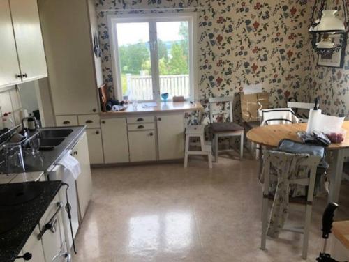 a kitchen with a table and a dining room at Huset i skogen med utsikten in Vallsta