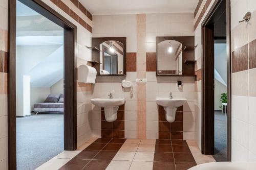 uma casa de banho com 2 lavatórios e um espelho em Hotel Cztery Pory Roku em Głogów Małopolski