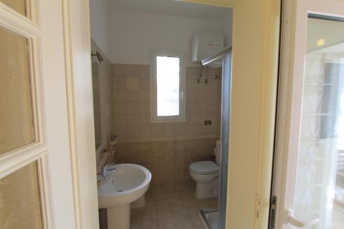 a bathroom with a toilet and a sink at Country Salenthouse in Marina di Mancaversa