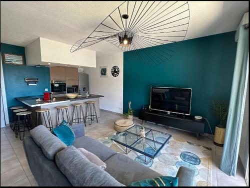 - un salon avec un canapé gris et un mur bleu dans l'établissement T2 chaleureux avec grande terrasse vue mer, à Bastia