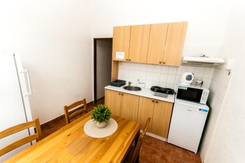 uma pequena cozinha com uma mesa de madeira, uma mesa e um frigorífico em Ubytování nad Vltavou em Týn nad Vltavou