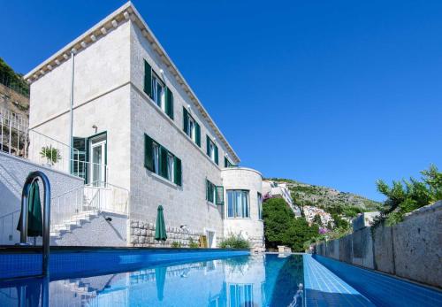 ein Gebäude mit einem Pool davor in der Unterkunft Villa Grande Bukovca - Beautiful 5 bedroom villa - Sea views - Glamorous location in Dubrovnik
