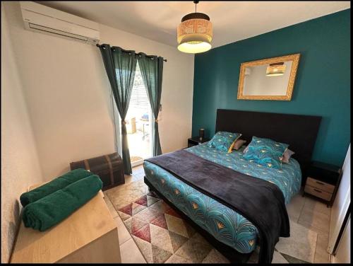 - une chambre avec un lit aux murs bleus et un miroir dans l'établissement T2 chaleureux avec grande terrasse vue mer, à Bastia