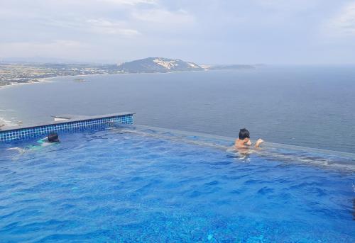 a woman sitting in a swimming pool in the water at Apec Mandala Mũi Né in Ấp Long Sơn