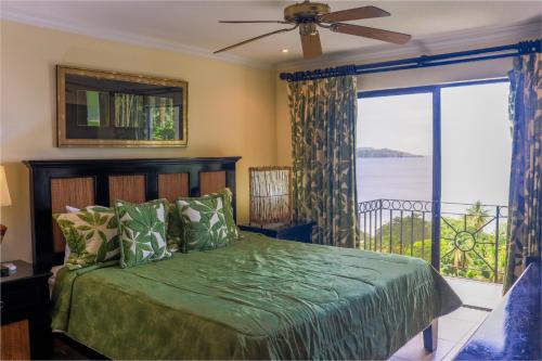 a bedroom with a green bed and a balcony at Oceanica 804 in Playa Flamingo