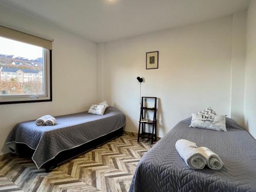 um quarto com 2 camas e uma janela em Disfruta la vista del Canal de Beagle! Departamento tranquilo rodeado de Árboles y montañas em Ushuaia