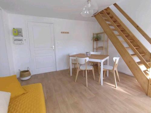 une salle à manger avec une table et des chaises et un escalier dans l'établissement l'appartement du château, à Boulogne-sur-Mer