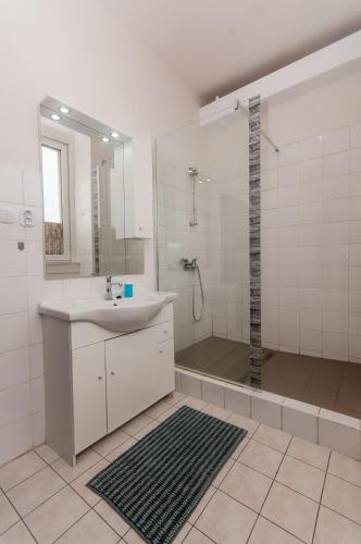 a white bathroom with a sink and a shower at Hostel Favorit in Týn nad Vltavou