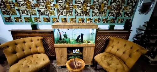 une chambre avec un aquarium et deux chaises dans l'établissement WİND HOTEL, à Sakarya