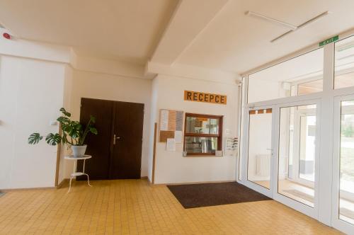 an empty room with a door and a potted plant at Hostel Favorit in Týn nad Vltavou