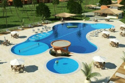 a large swimming pool with chairs and umbrellas at Apartamento no Villa das Águas in Estância