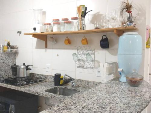 a kitchen counter with a mixer and a sink at Apartamento no Villa das Águas in Estância
