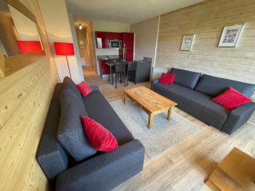 - un salon avec un canapé bleu et des oreillers rouges dans l'établissement Studio rénové 35 m² - 4/6 couchages - A coté des pistes - terrasse vue montagne, à Orcières