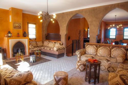 a large living room with couches and a fireplace at Chambre Agdz, Riad 2 Couple only au village naturiste in Cap d'Agde