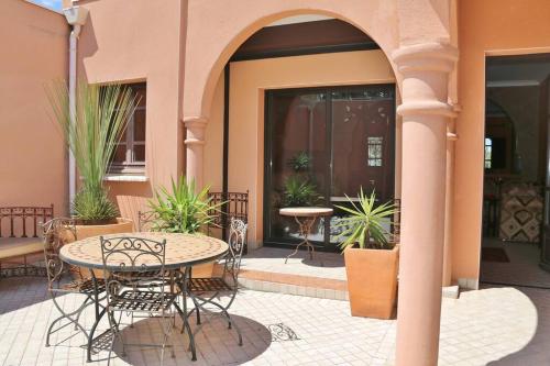 a patio with a table and chairs in front of a building at Chambre Agdz, Riad 2 Couple only au village naturiste in Cap d'Agde