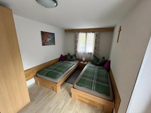 ein kleines Zimmer mit 2 Betten und einem Fenster in der Unterkunft Ferienwohnung Annamaria und Manuel Melmer in Sankt Leonhard im Pitztal