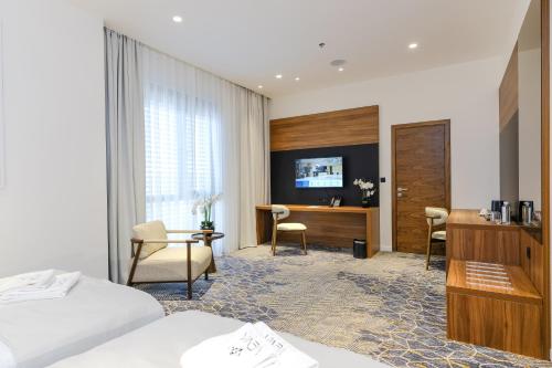 a hotel room with two beds and a desk at Hotel Vema in Visoko