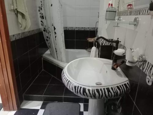 a black and white bathroom with a sink and a tub at شبرا مصر in Cairo