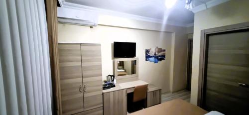 a room with a bedroom with a desk and a television at WİND HOTEL in Sakarya