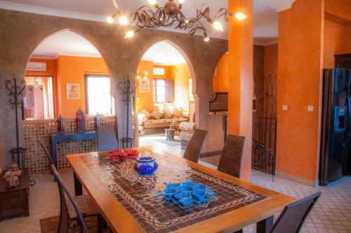 uma sala de jantar com uma mesa com vasos azuis em Suite Bradia, Riad 2 Couple only au village naturiste em Cap d'Agde