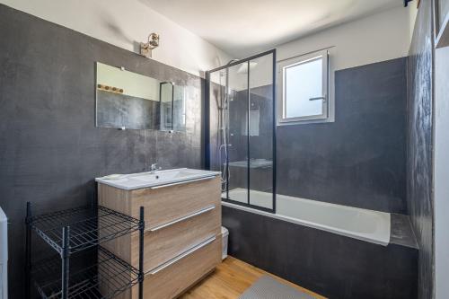 y baño con lavabo, bañera y ducha. en Le Cottage de Flore - Avec piscine privée chauffée en Saint-Jean-la-Poterie
