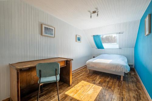 ein Schlafzimmer mit einem Bett und einem Schreibtisch mit Stuhl in der Unterkunft Le Cottage de Flore - Avec piscine privée chauffée in Saint-Jean-la-Poterie