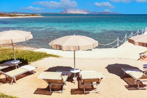 a beach with chairs and umbrellas and the ocean at AMASEA Resort in San Teodoro