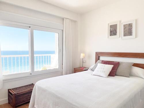 a white bedroom with a bed and a large window at Summerlandrota Cordoba8 in Rota