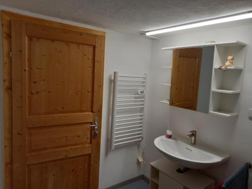 a bathroom with a wooden door and a sink at 60 m² Ferienapartment Zentrumsnahe mit Gartenbenutzung in Steyr