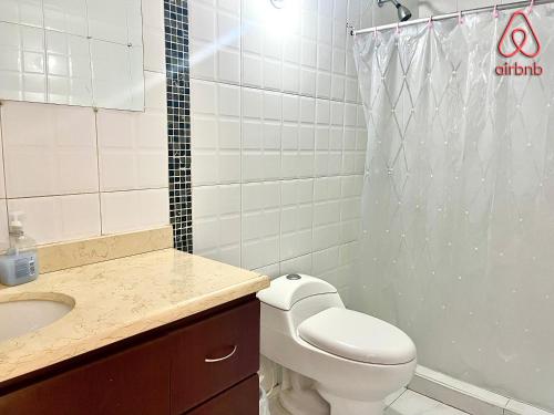 a bathroom with a toilet and a sink and a shower at A 5 minutos de Aeropuerto Dorado in Bogotá