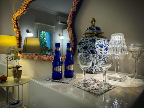 een tafel met flessen en glazen en een vaas bij hi HOTEL IVY BÜYÜKADA in Adalar