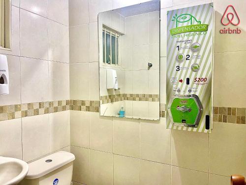 a bathroom with a toilet and a sink and a mirror at A 5 minutos de Aeropuerto Dorado in Bogotá