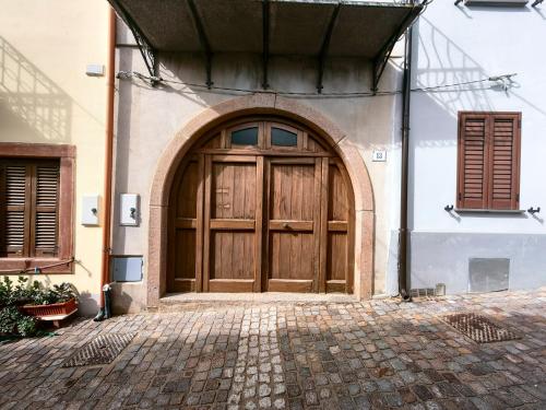 una grande porta di legno sul lato di un edificio di Corte 'e Susu a Ortueri