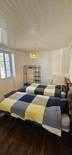 une chambre avec deux lits et un lustre dans l'établissement Maison de village, à Sadroc